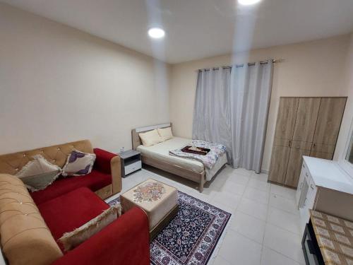 a living room with a couch and a bed at Friends Hotel Apartments in Ajman 