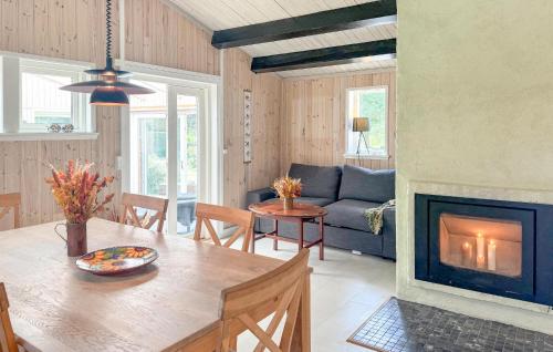 a living room with a table and a fireplace at 2 Bedroom Nice Home In Stenlille in Stenlille