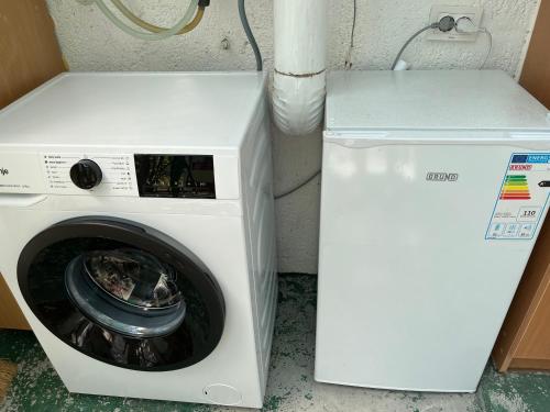 a white washing machine next to a small refrigerator at Green Oasis Retreat in Bar