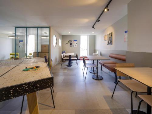 a waiting room with tables and chairs and a table at ibis budget Forbach Centre in Forbach