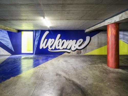 a parking garage with a lit up sign on the wall at ibis budget Forbach Centre in Forbach