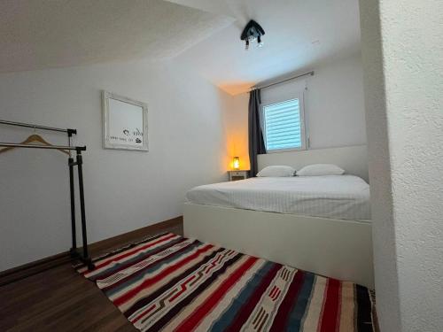 a bedroom with a bed and a window and a rug at appartement cosy in Tafers