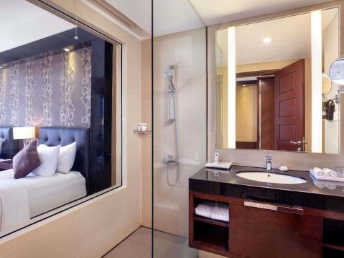 a bathroom with a sink and a shower at Grand Mercure Solo Baru in Solo