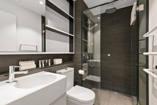 a bathroom with a toilet and a sink and a shower at District Apartments Fitzroy in Melbourne