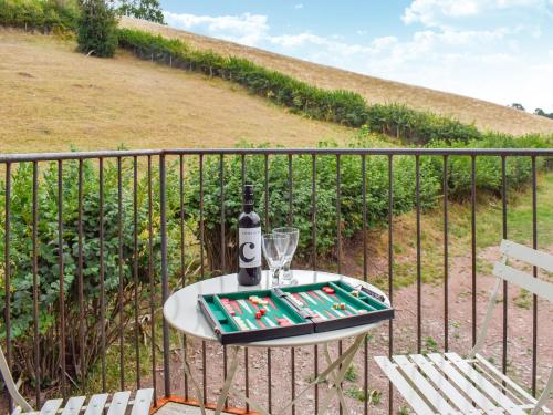 a table with a wine bottle and glasses on a fence at The Granary - Uk50401 in Llanstephan