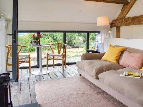 a living room with a couch and a table with chairs at The Granary - Uk50401 in Llanstephan
