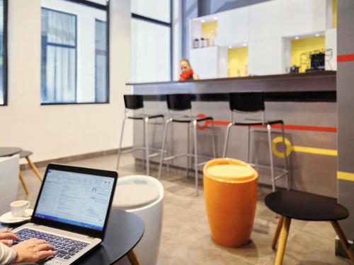 a person sitting at a table with a laptop at ibis Styles Marseille Gare Saint-Charles in Marseille