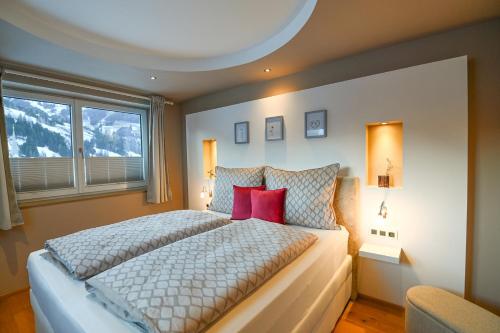 a bedroom with a large bed with red pillows at Chalet Creatina by we rent, NATIONALPARK CARD INCLUDED in Rauris