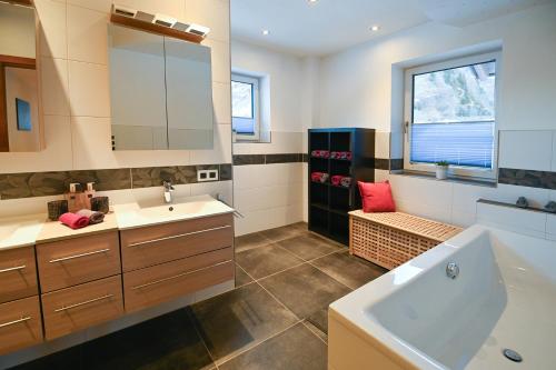 a bathroom with a tub and a sink and a bath tub at Chalet Creatina by we rent, NATIONALPARK CARD INCLUDED in Rauris