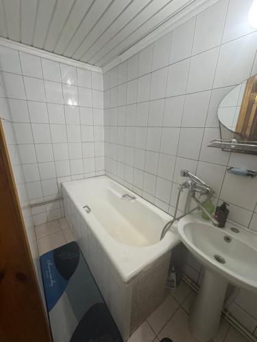 a white bathroom with a tub and a sink at Дім дача біля води in Protsev