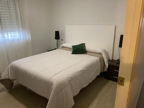 a bedroom with a bed with a green pillow on it at Mi Descanso in Córdoba