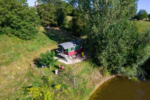 an aerial view of a house on a hill next to a river at Ecrin du Ségala - Roulotte insolite in Tauriac-de-Naucelle