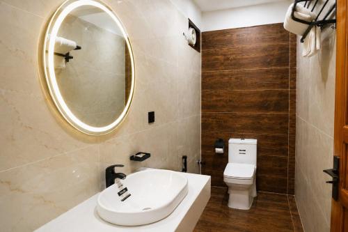 a bathroom with a sink and a mirror and a toilet at Elite Creek Clifton in Karachi