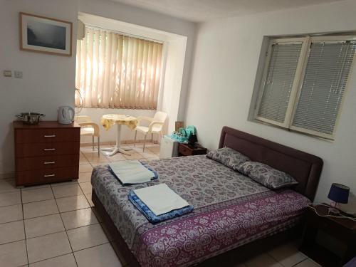 a bedroom with a bed and a table and chairs at Zorica in Rafailovici
