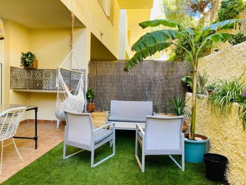 a patio with chairs and a table and swing at Marta Beach House - Caños De Meca in Los Caños de Meca