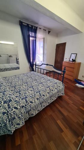 a bedroom with a bed and a window and wooden floors at Casa Clelia e Aida in Roccatederighi