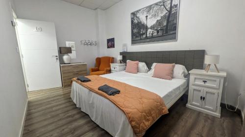 a bedroom with a large bed with pink pillows at The Cathedral Hostel in Murcia