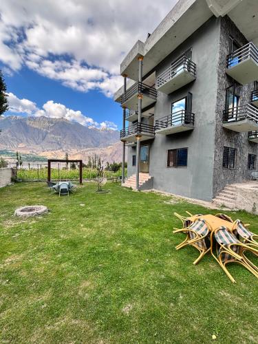 two chairs sitting on the grass next to a building at Gold Star Hotel Skardu in Skardu
