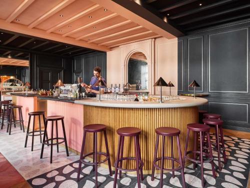a bar with stools at a counter in a restaurant at Mama Shelter Rennes in Rennes