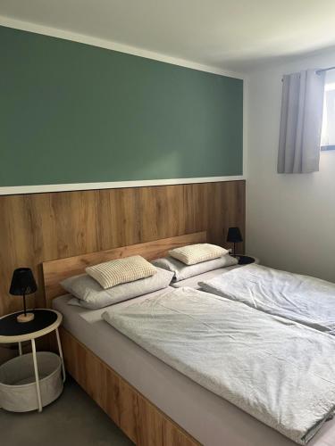 a bedroom with a large bed with a wooden headboard at Ferienhaus Friedrich 22 in Kolkwitz