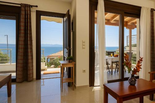 a living room with sliding glass doors and a dining table at Seaside Getaway - Aelia Villa's Dreamy Paradise in Petalidi