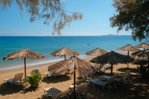 a beach with chairs and umbrellas and the ocean at Seaside Getaway - Aelia Villa's Dreamy Paradise in Petalidi