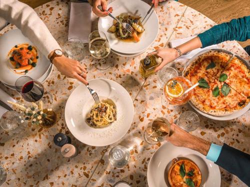 a group of people sitting around a table eating food at Le Saint Gervais Hotel & Spa Handwritten Collection in Saint-Gervais-les-Bains