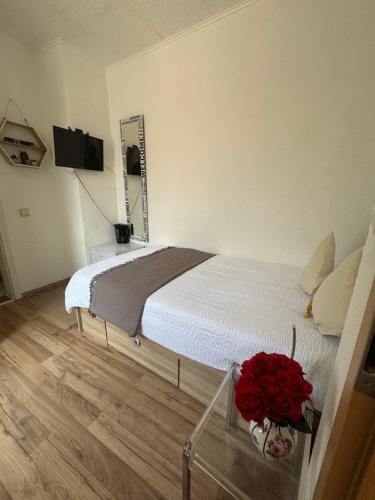a bedroom with a bed with red roses on a table at Baden-Baden Zentrum Studio in Baden-Baden