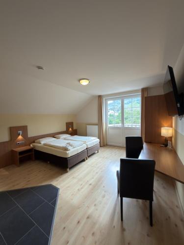 a large bedroom with a bed and a chair at Hotel & Restaurant Brühler Hof in Wintrich