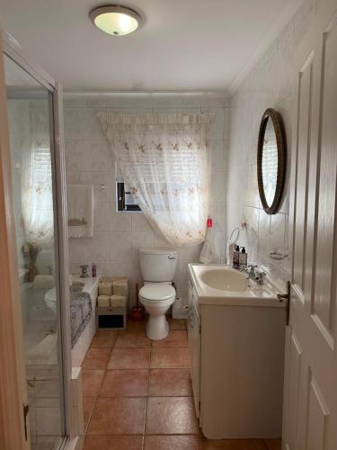 a bathroom with a toilet and a sink and a tub at De Kleine Herberg in Durbanville
