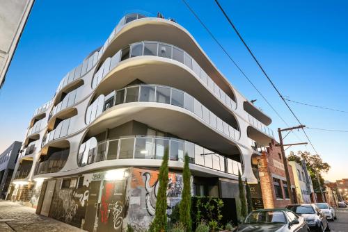 a white building on the side of a street at District Apartments Fitzroy in Melbourne