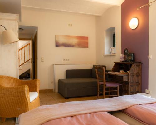 a room with a bed and a couch and a table at Fliederhof Stücken Apartments bei Potsdam in Michendorf