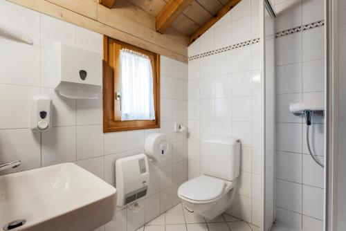a white bathroom with a toilet and a sink at Osteria Ascona in Ascona