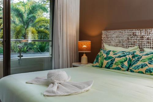 a bed with a towel on it with a window at NEW Beachfront 3-bedrooms Apartment in Tamarin, Ocean Legend in Tamarin
