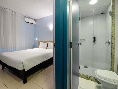 a bedroom with a bed and a shower and a toilet at ibis Styles Manaus in Manaus