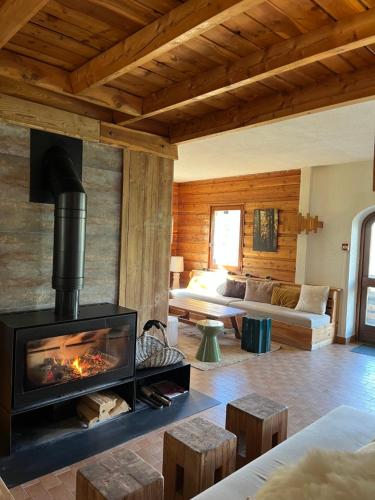 a living room with a fireplace and a couch at Le Grand Tetras in Saint-Véran