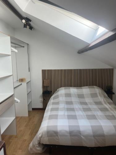 a bedroom with a bed with a checkered blanket at L'Envol in Tillé