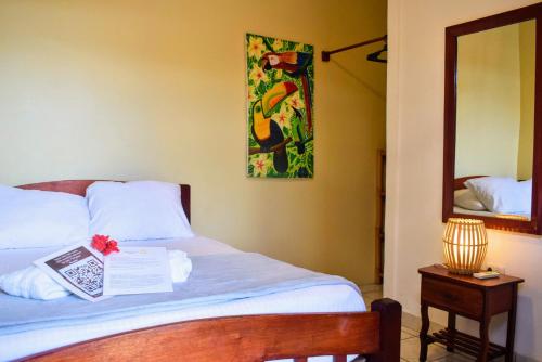 a bedroom with a bed with a mirror and a bed sidx sidx sidx at Chale's House Hotel in San Juan del Sur
