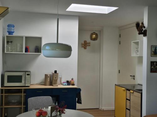 a kitchen with a table and a microwave at B&B Le Maitre in Renkum
