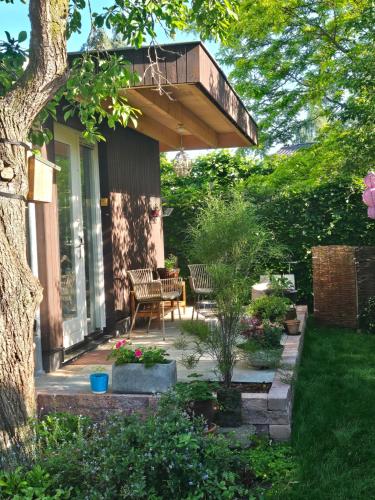 a patio with a table and chairs under a balcony at B&B Le Maitre in Renkum