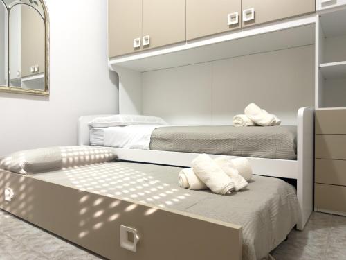 a bedroom with two beds and a mirror at Unit 120 in SantʼAgata di Militello