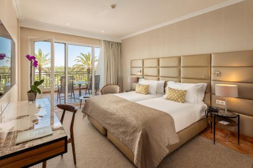 a hotel room with a large bed and a balcony at Ria Park Hotel & Spa in Vale do Lobo