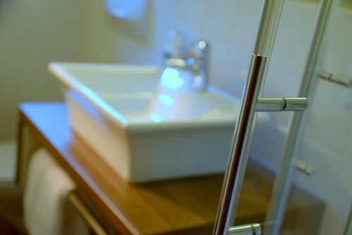 a bathroom sink with aaucet on a wooden table at BELVEDERE - das BIO HOTEL Garni & SuiteHotel am Edersee ! Unser Geschenk für Sie, auch die GästeCard GrimmHeimat! in Waldeck