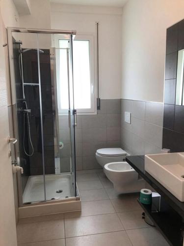 a bathroom with a shower and a toilet and a sink at Residence Acquasuite in Martinsicuro