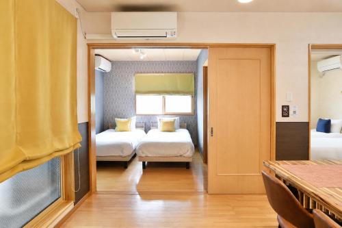 a hotel room with two beds and a window at Chillax Hida Takayama in Takayama