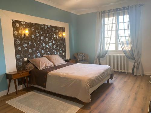 a bedroom with a large bed and a window at Oasis de Vic in Vic-Fezensac