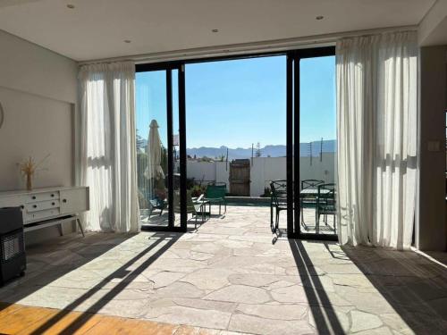 a large living room with sliding glass doors with a view at Beach Paradise in Muizenberg