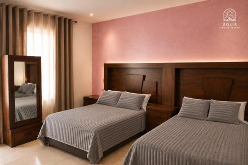 a hotel room with two beds and a mirror at Habitación Privada in Jacuaro