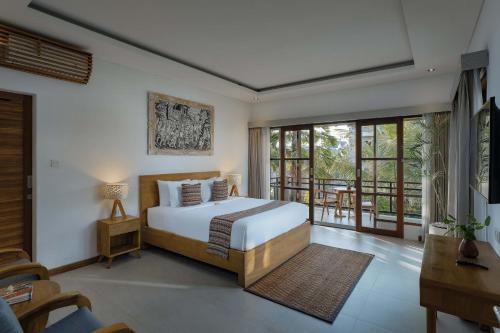 a bedroom with a bed and a balcony at Villa Mirah Ubud in Ubud