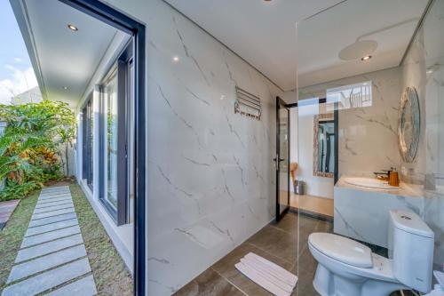 a bathroom with a toilet and a walk in shower at Villa Mirah Ubud in Ubud